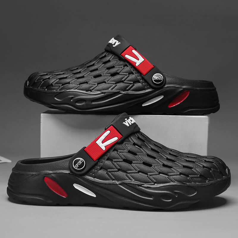 Black sandals with red accents on a gray background