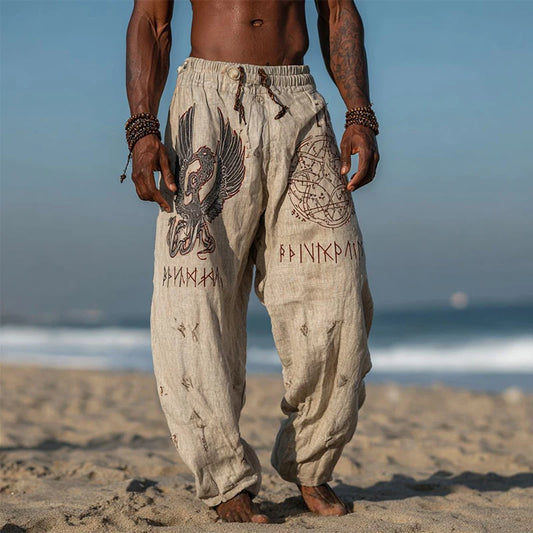 Person wearing patterned pants on a beach with ocean in the background