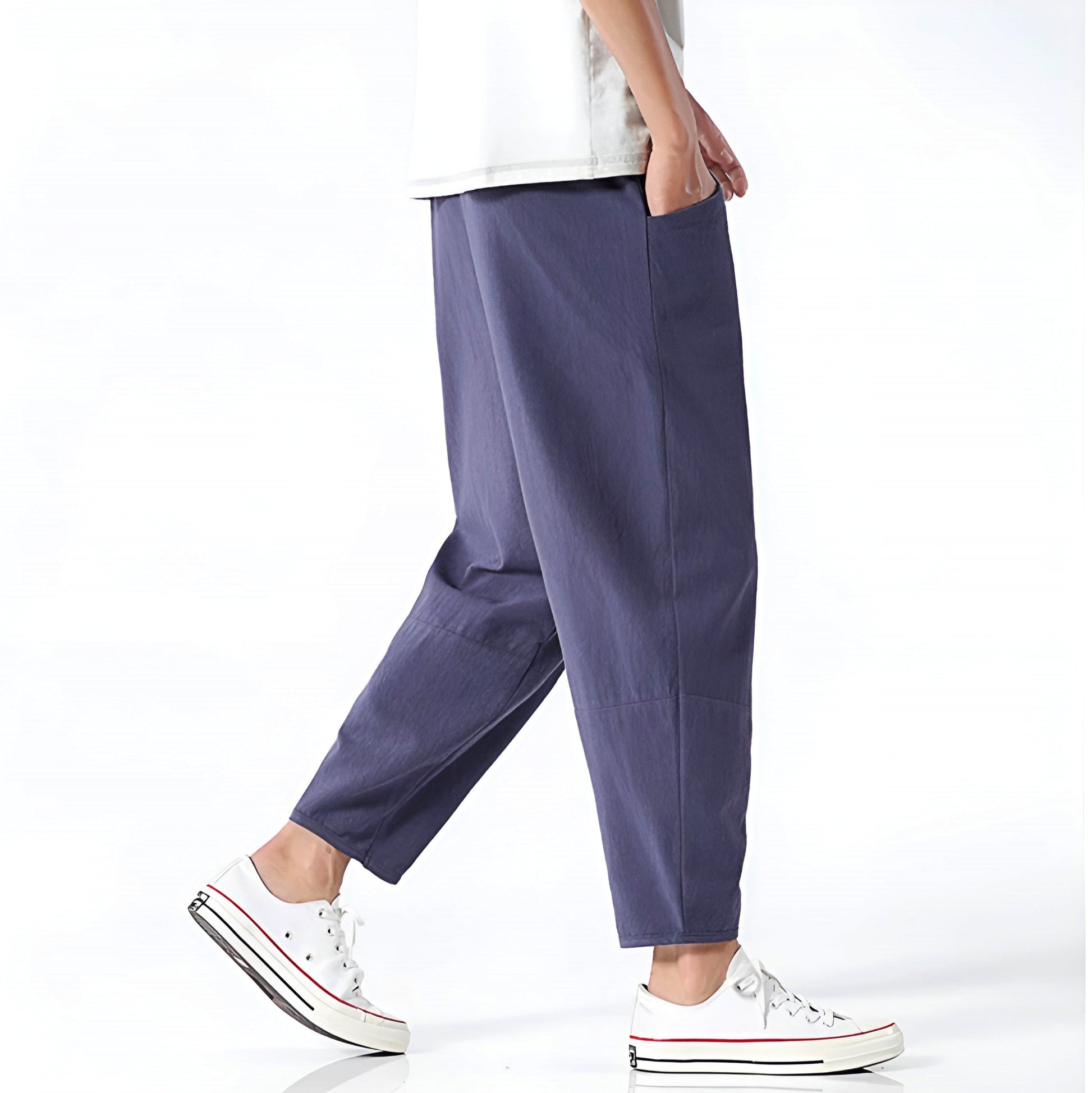 Person wearing purple pants and white sneakers on a white background