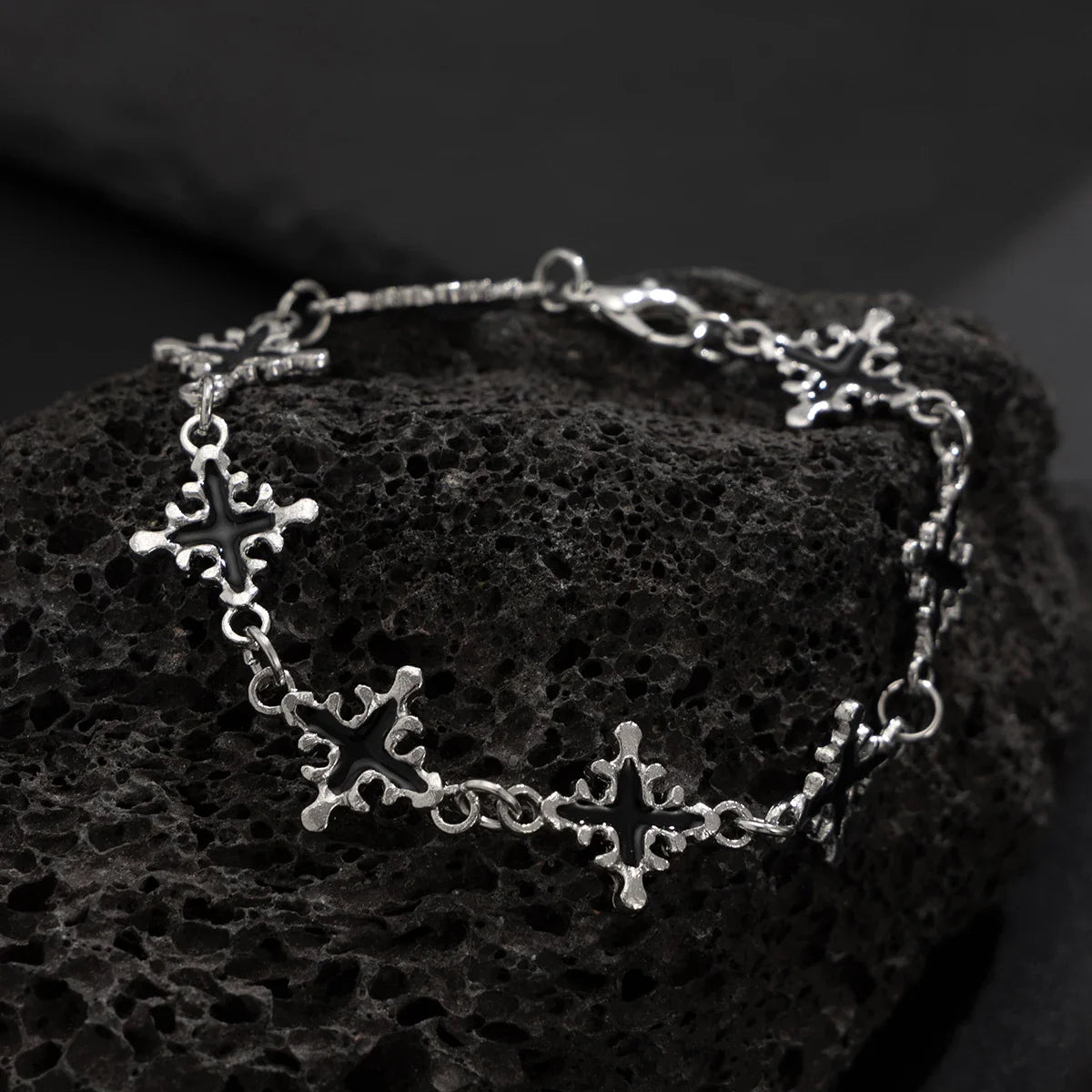 Silver bracelet with star designs on a textured black surface