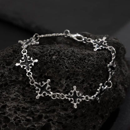 Silver bracelet with star designs on a textured black surface